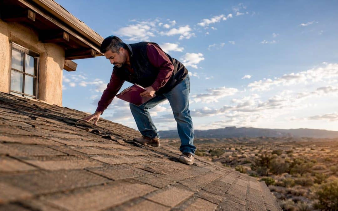 Man inspecting New Mexico residential roof shingles