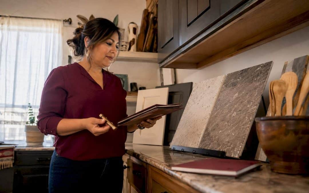 Woman comparing countertop slabs in kitchen showroom