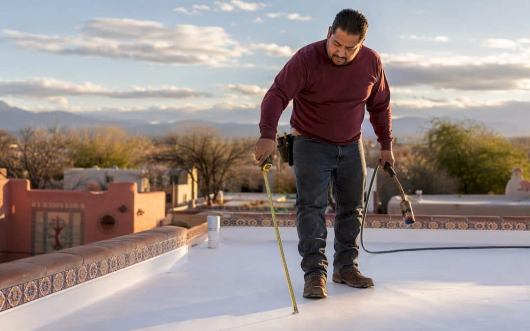 Contractor inspecting TPO roofing on Albuquerque home