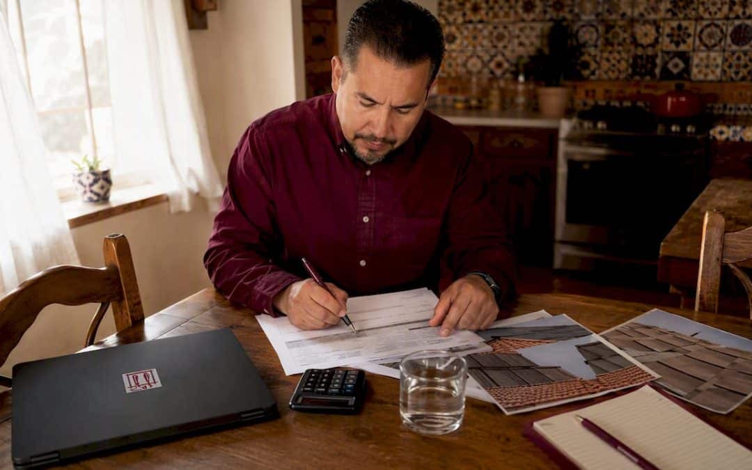 Man reviewing roofing cost estimates at desk